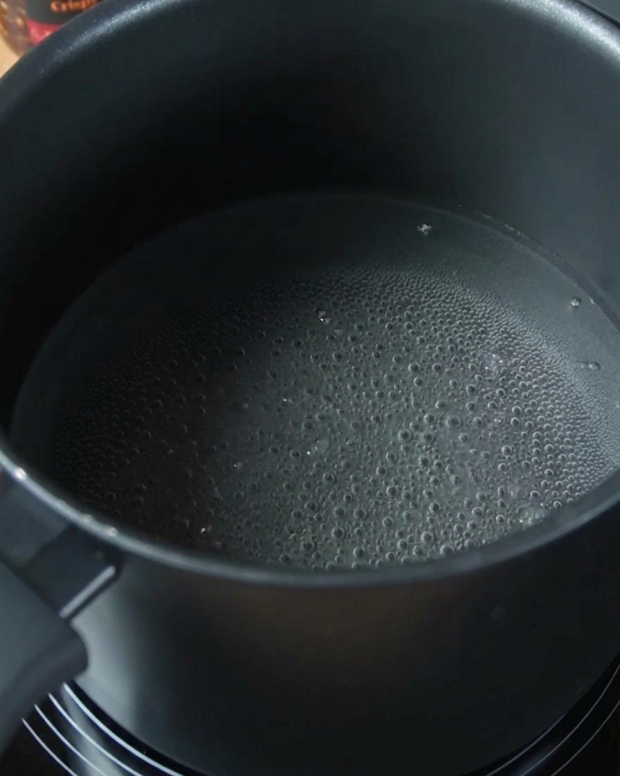 Spaghetti-Nudeln garen in einem Topf mit kochendem Wasser.