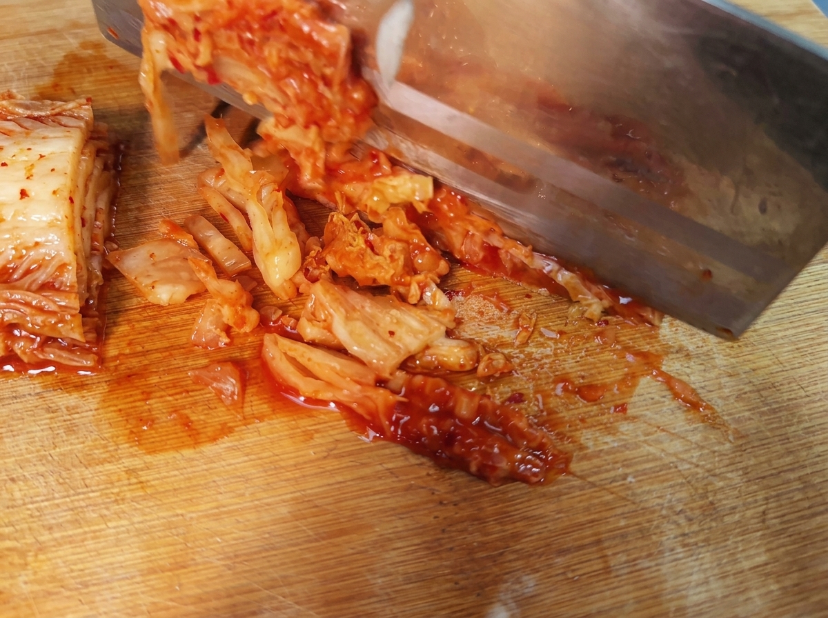 Streifen von würzigem koreanischem Kimchi auf einem Schneidebrett.
