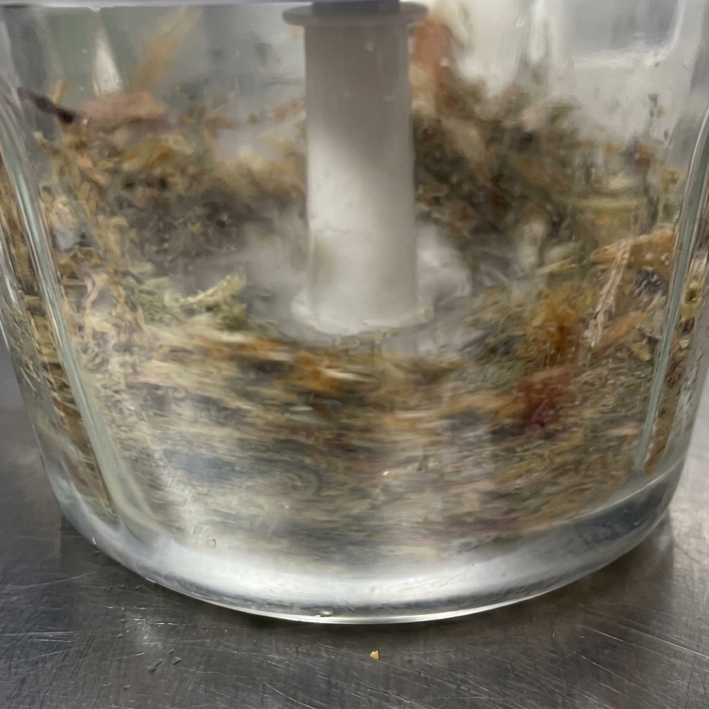 Das feine Fischpulver wird in die flüssige Saucenbasis im Metalltopf gegeben.