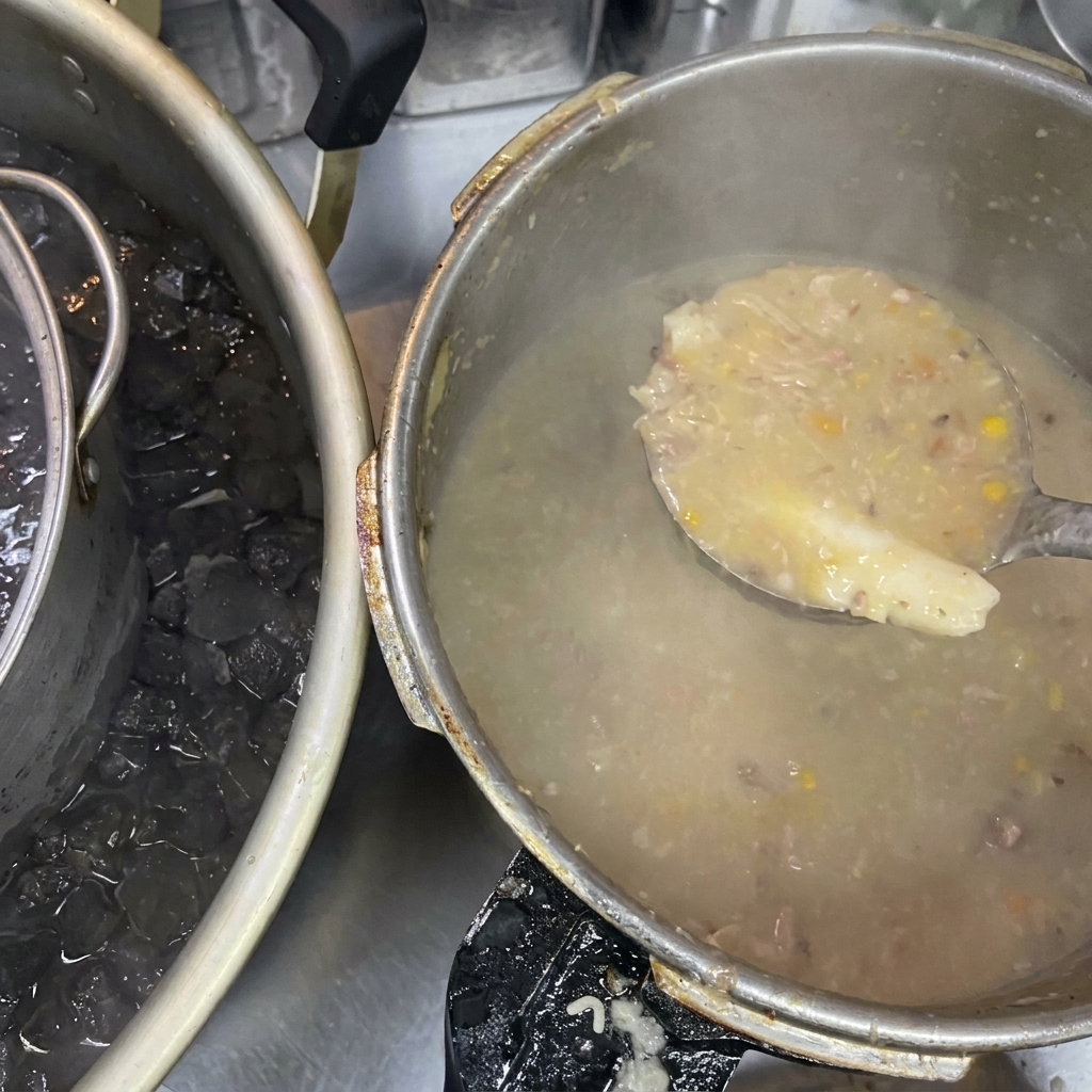 Eine Schöpfkelle mit dicker, trüber Brühe neben einem großen Topf, der in einem Eisbad steht.