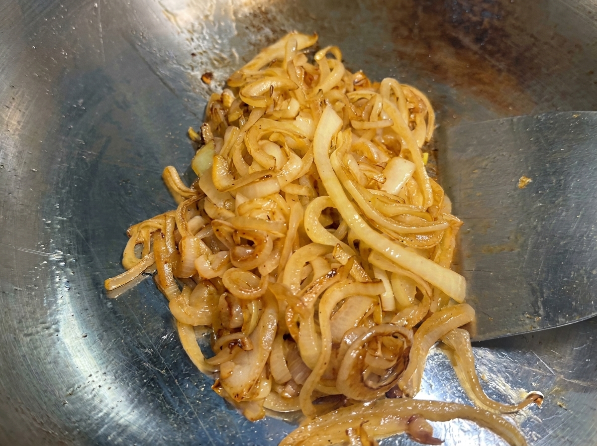 Die Zwiebeln auf dem Grill sind zu einer tiefgoldenen, karamellisierten Masse eingekocht.
