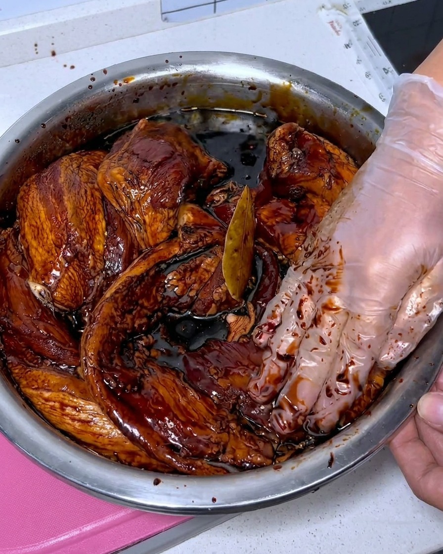 Frische Schweinebauchstreifen werden in einer Edelstahlschüssel mit Baijiu gereinigt.
