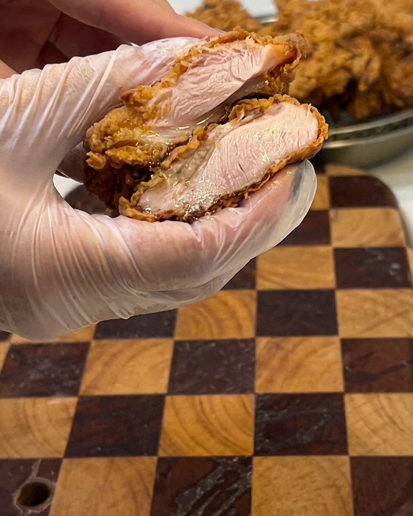 Ein aufgeschnittenes Hähnchenfilet zeigt das saftige, weiße Fleisch im Inneren.