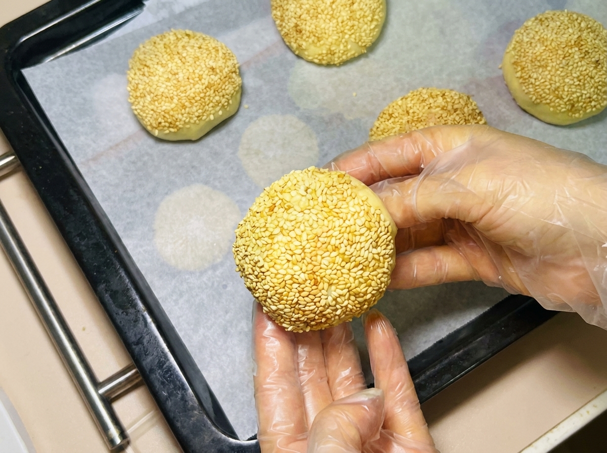 Eine Teigkugel wird auf einem mit Backpapier ausgelegten Blech platziert.