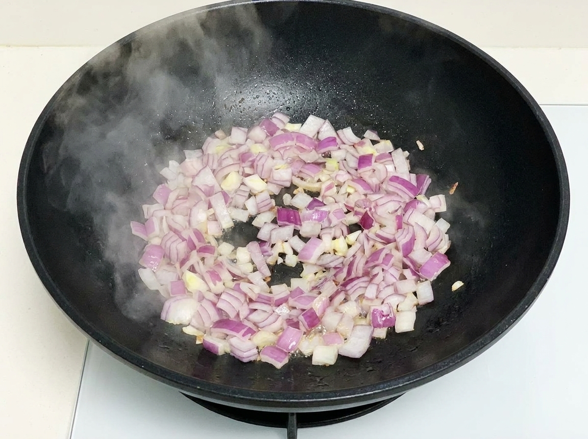 Gehackte rote Zwiebeln in einem heißen Wok.