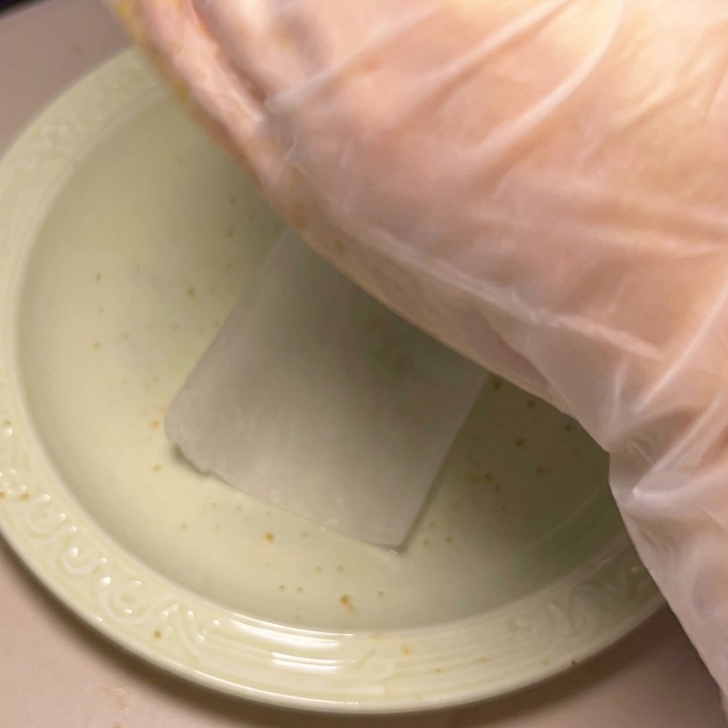 Eine Hand formt eine Portion Hackfleisch zu einem runden Patty.