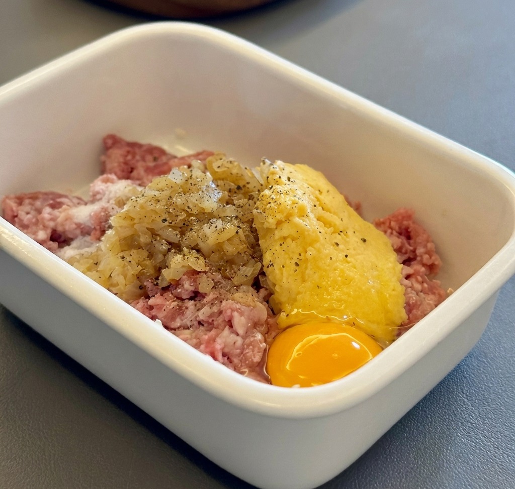 Zutaten für die Hamburg Steak Pattys in einem weißen Behälter gemischt.