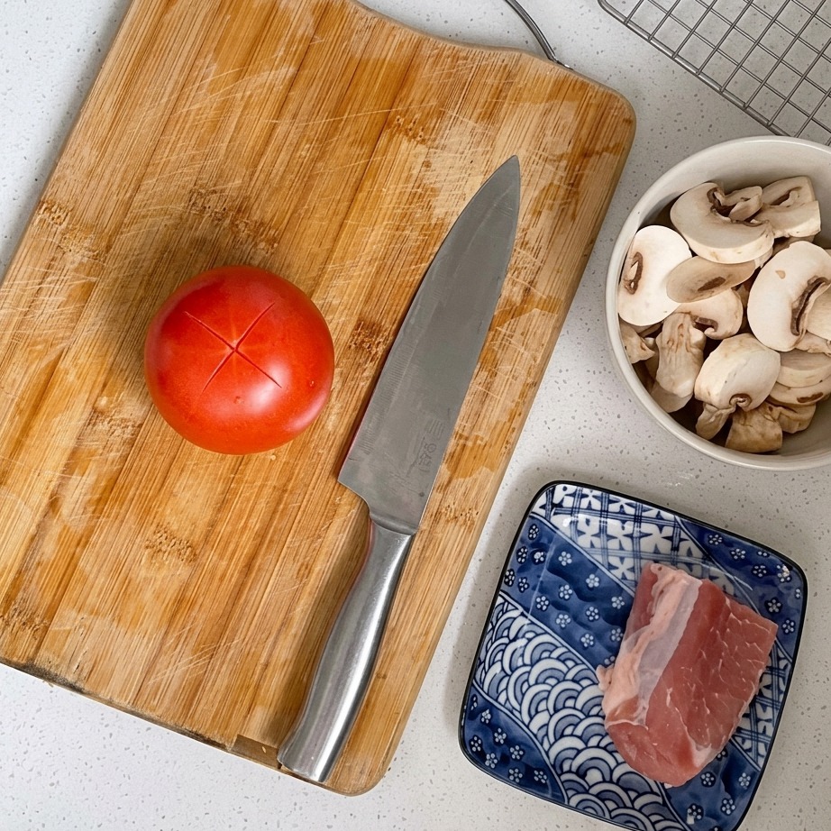 Nahaufnahme einer roten Tomate, deren Haut auf der Oberseite kreuzweise eingeritzt ist.