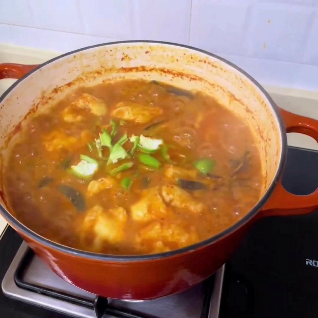Frische grüne Chilisheiben werden über die sprudelnde, reichhaltige koreanische Muschelsuppe gestreut.
