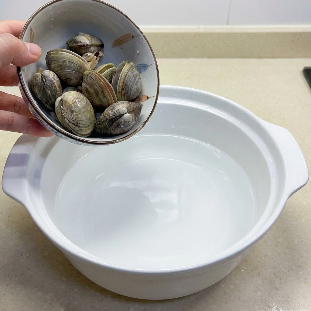 Eine Schüssel mit mehreren rohen Venusmuscheln, bereit zum Kochen.