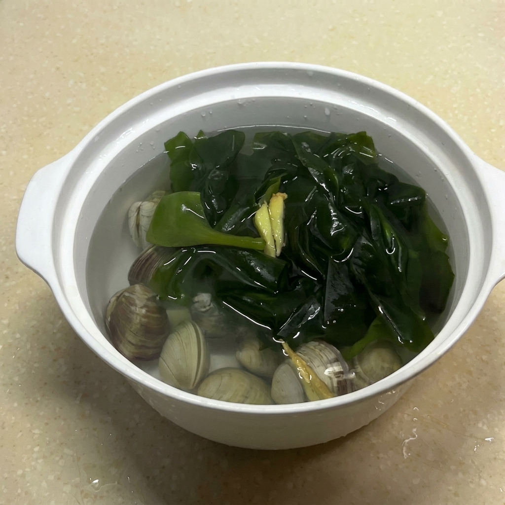 Die Schüssel mit Muscheln, Algen, Ingwer und Wasser nach der Zugabe von Salz.
