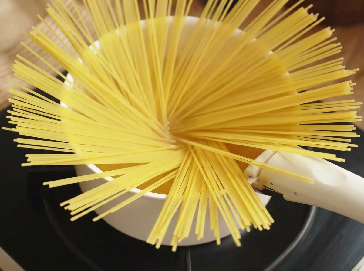 Spaghetti werden in das kochende Wasser gegeben.