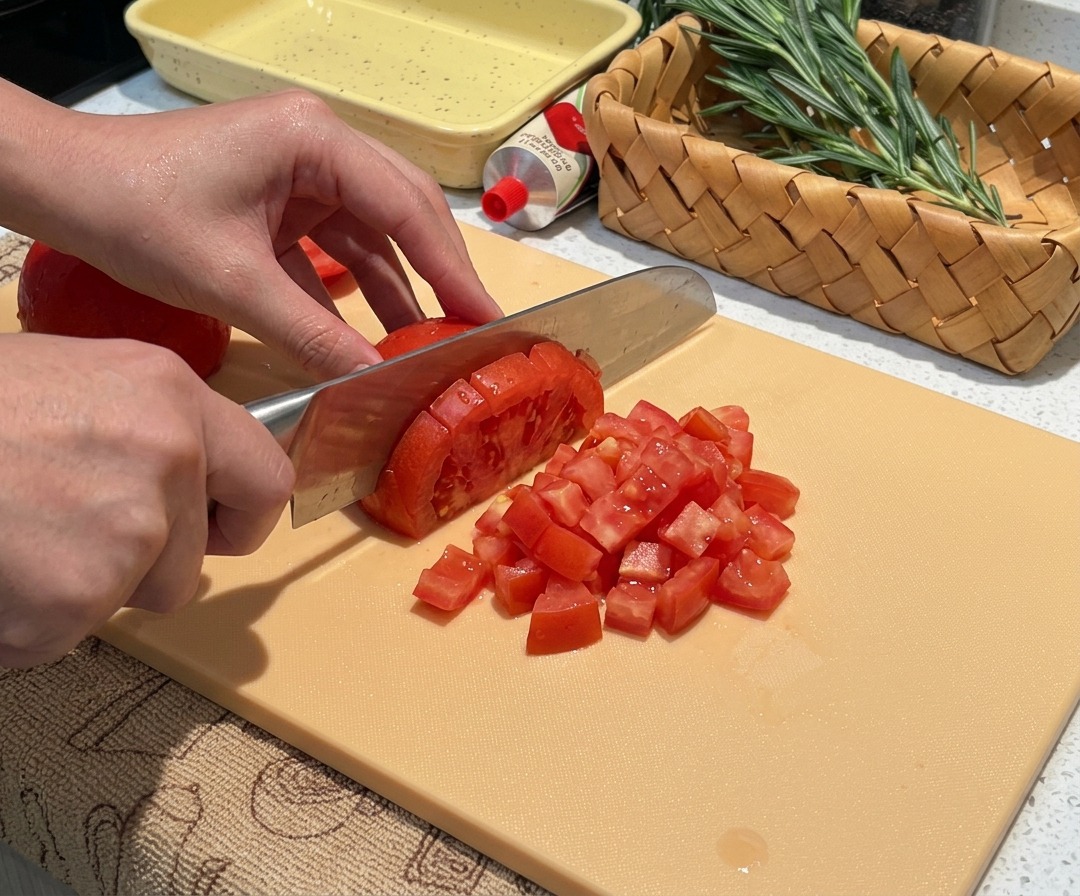 Frisch gehäutete Tomaten werden in kleine, gleichmäßige Stücke gewürfelt.
