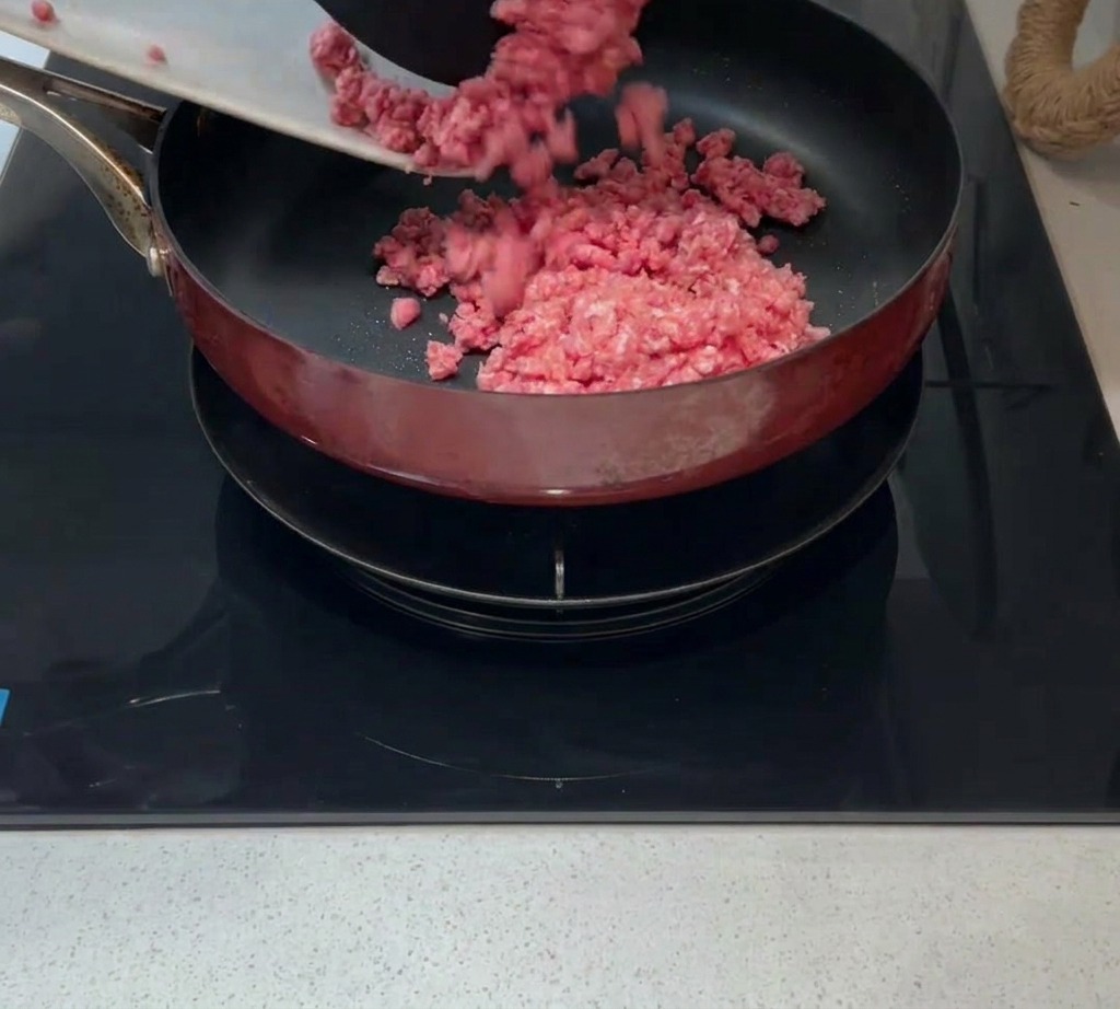Rohes Hackfleisch wird in eine heiße Pfanne mit etwas Öl gegeben.