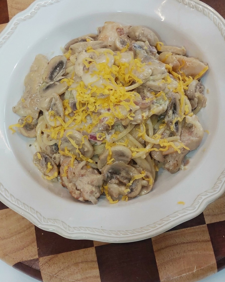 Käse wird direkt über die angerichtete Pasta gerieben.