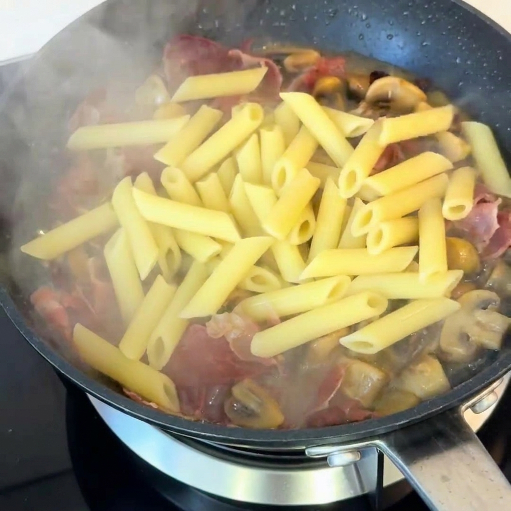 Die Pasta wird in der Pfanne mit frisch gemahlenem schwarzen Pfeffer gewürzt.
