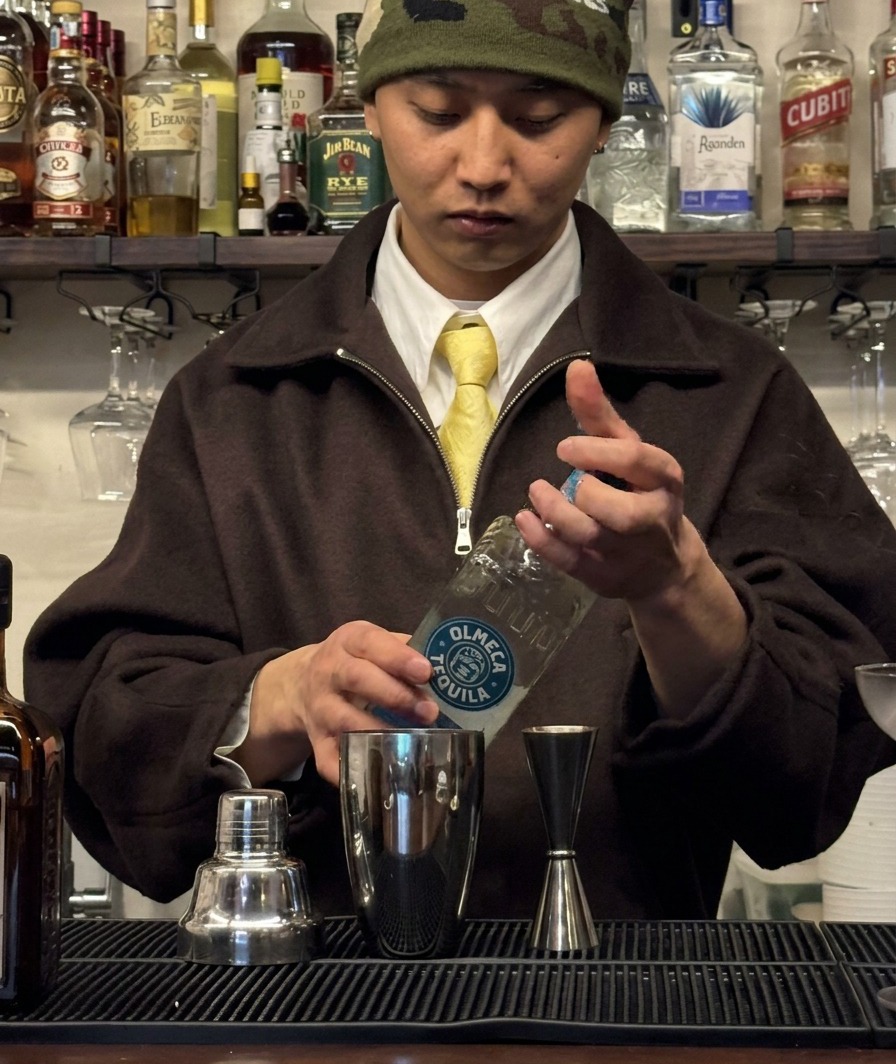 Tequila, der in einen Jigger abgemessen und in einen Cocktailshaker gegossen wird.