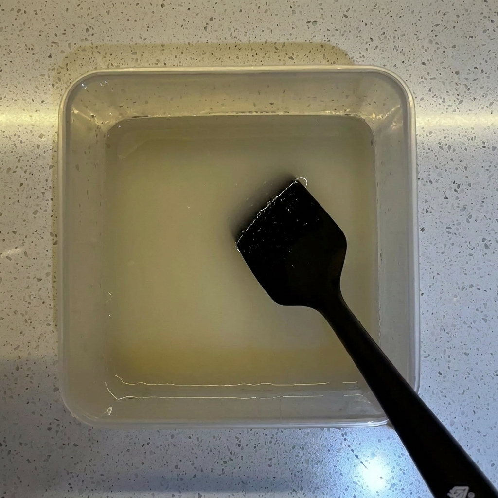 Mehl wird in einen durchsichtigen Behälter gegossen, der die vorbereitete Hefe-Wasser-Mischung enthält.