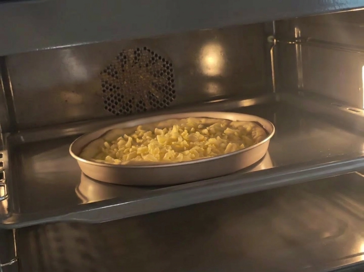 Eine Pfanne mit vorbereitetem Käsestangen-Teig steht in einem vorgeheizten Ofen.