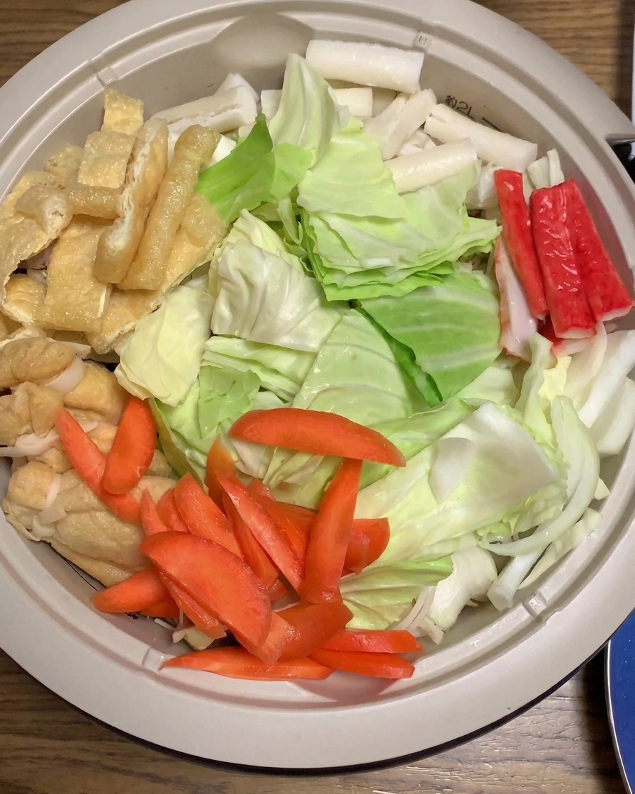 Miso-Sauce wird über die Schichten aus Kohl, Karotten, Surimi und anderen Zutaten gegossen.