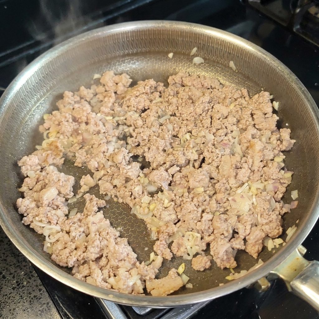 Kochwein und Miso-Paste werden unter das Fleisch gerührt.
