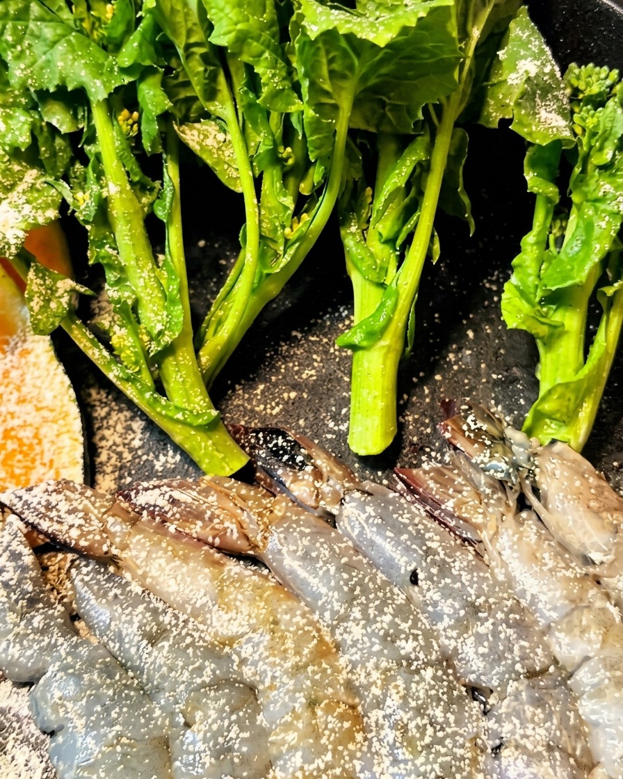 Garnelen und Auberginen werden mit Teig überzogen und in eine Fritteuse gegeben.