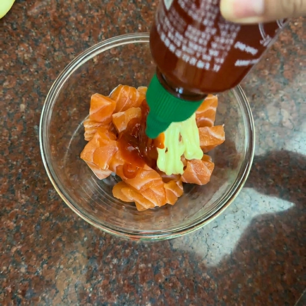 Mayonnaise, rote Chilisauce und Gewürze werden in einer Glasschüssel zusammengemischt.