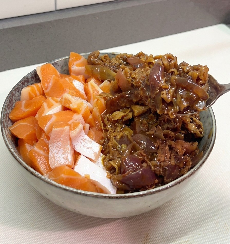 Ein Metalllöffel gibt eine Portion saftiges Rindfleisch mit lila Zwiebeln in die Schale neben den frischen Lachs.