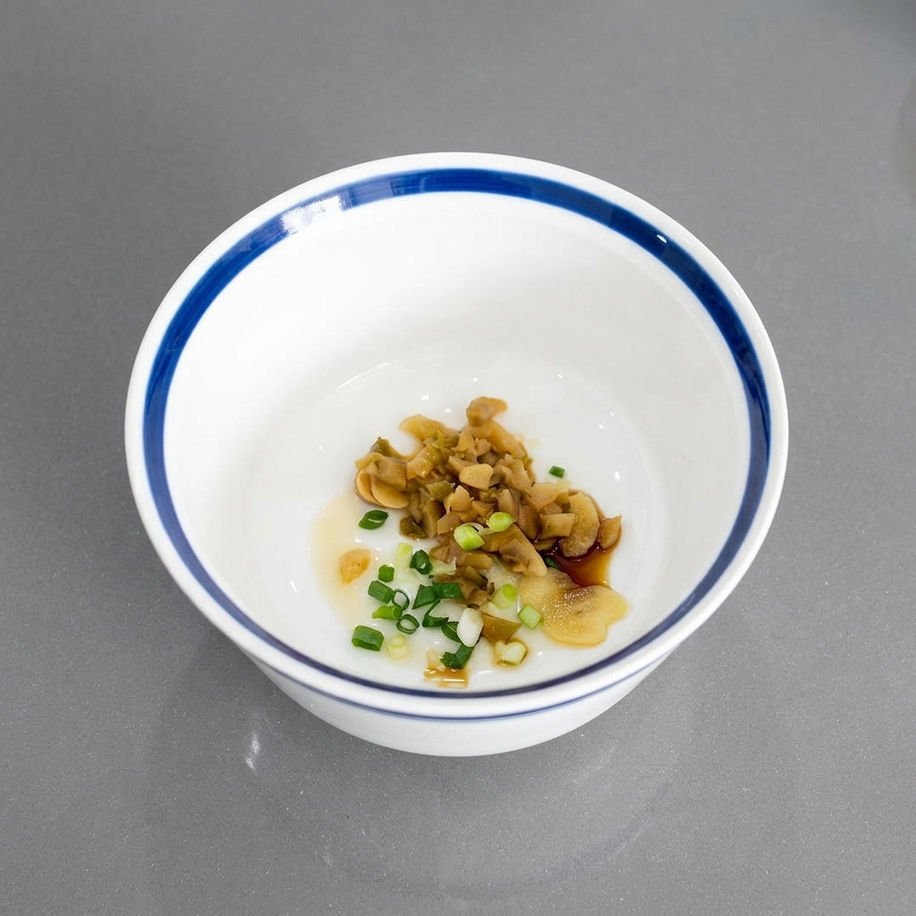 Gehackte Frühlingszwiebeln vermischt mit eingelegtem Gemüse und Knoblauch am Schalenboden.