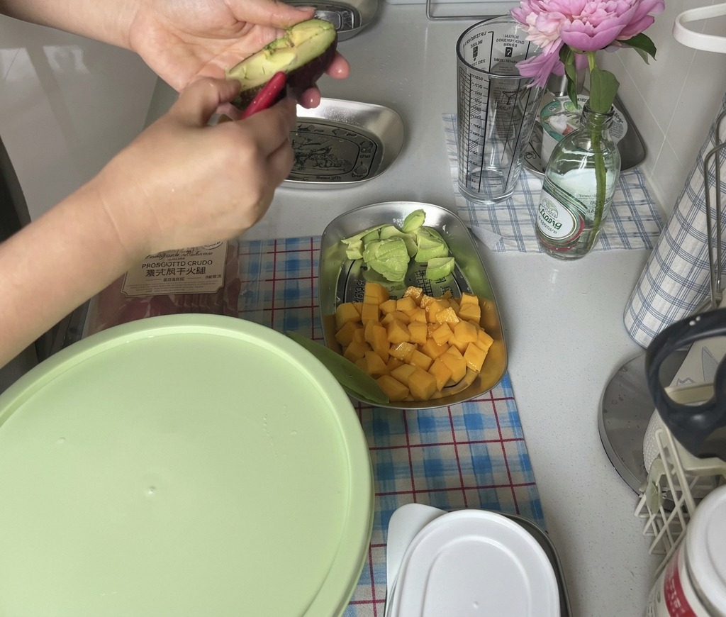 Hände drehen eine dunkle, reife Avocado auf, um an das Fruchtfleisch zu gelangen.