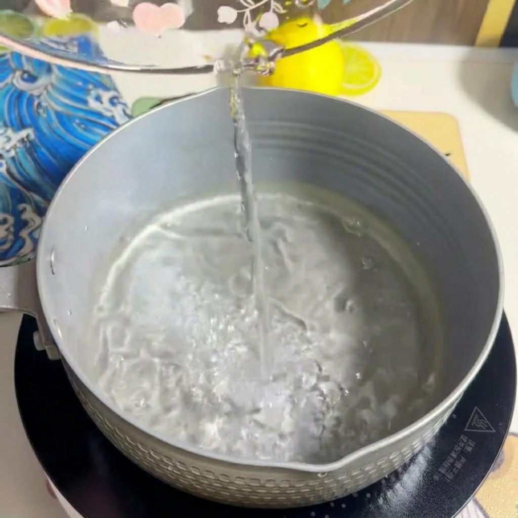 Milch wird in den Topf gegossen und vermischt sich mit dem Wasser.