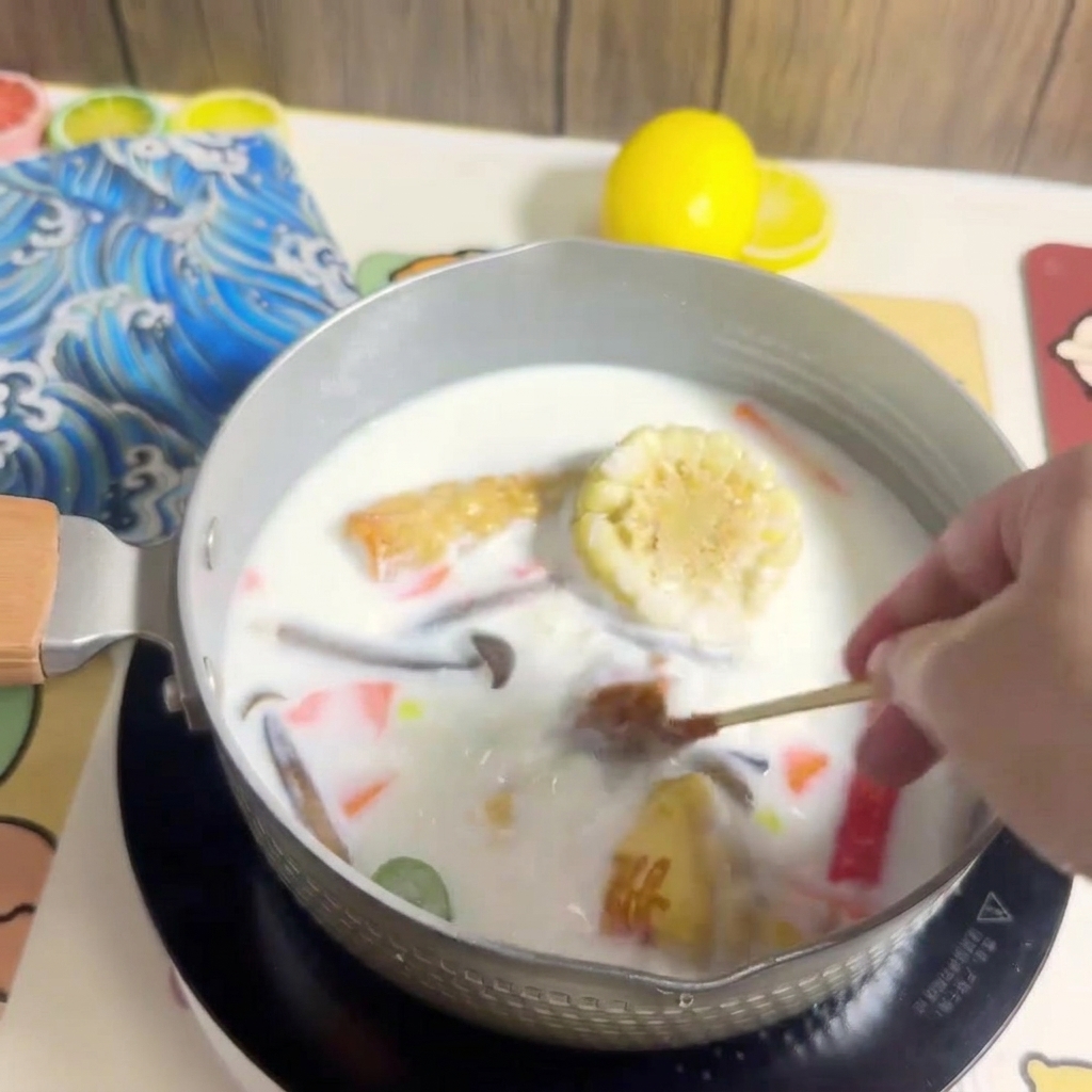 Ein Block Ramen-Nudeln wird in den Topf mit der köchelnden Brühe und den Zutaten gegeben.