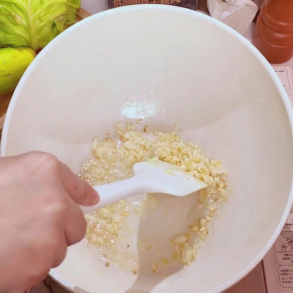 Gehackter Knoblauch wird in einer Pfanne mit Öl goldgelb angebraten.