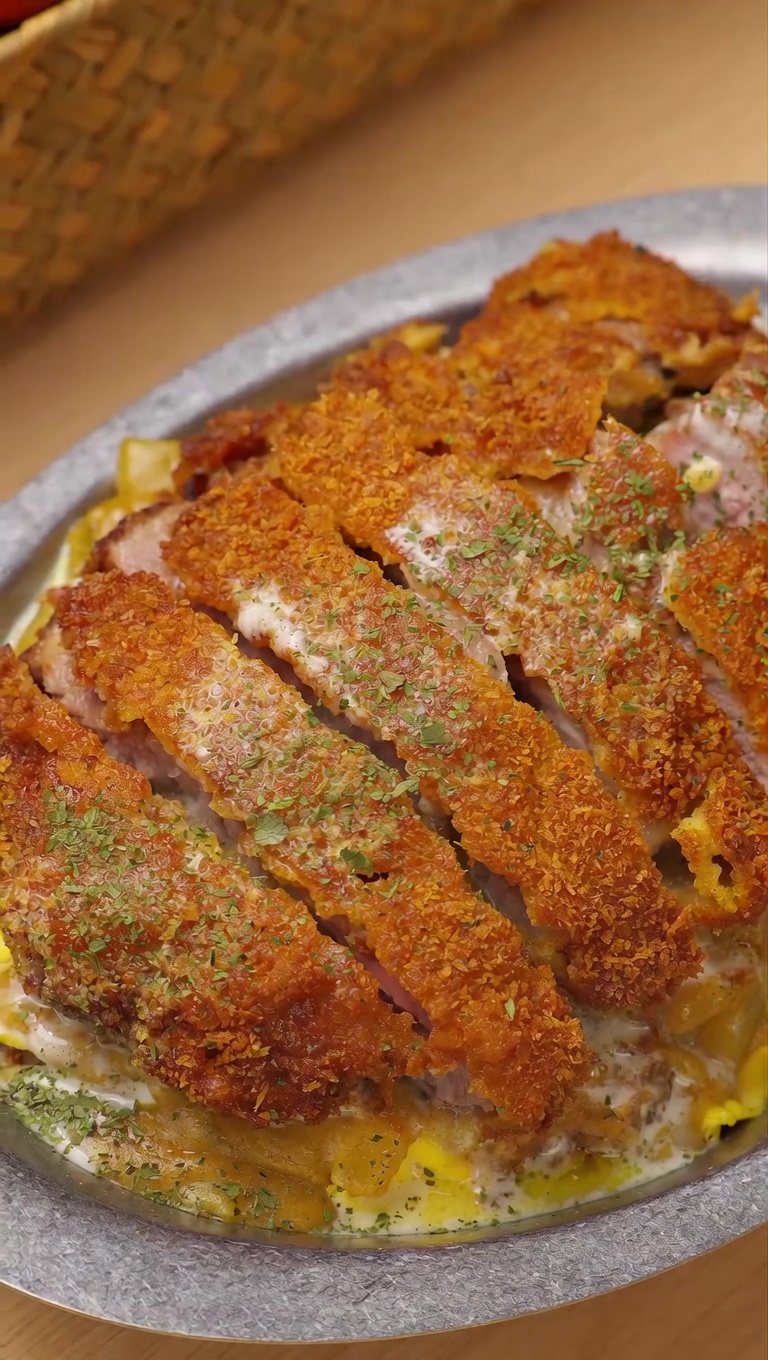 Knuspriges Kokos-Curry-Schweinekotelett mit Reis und Käsesauce