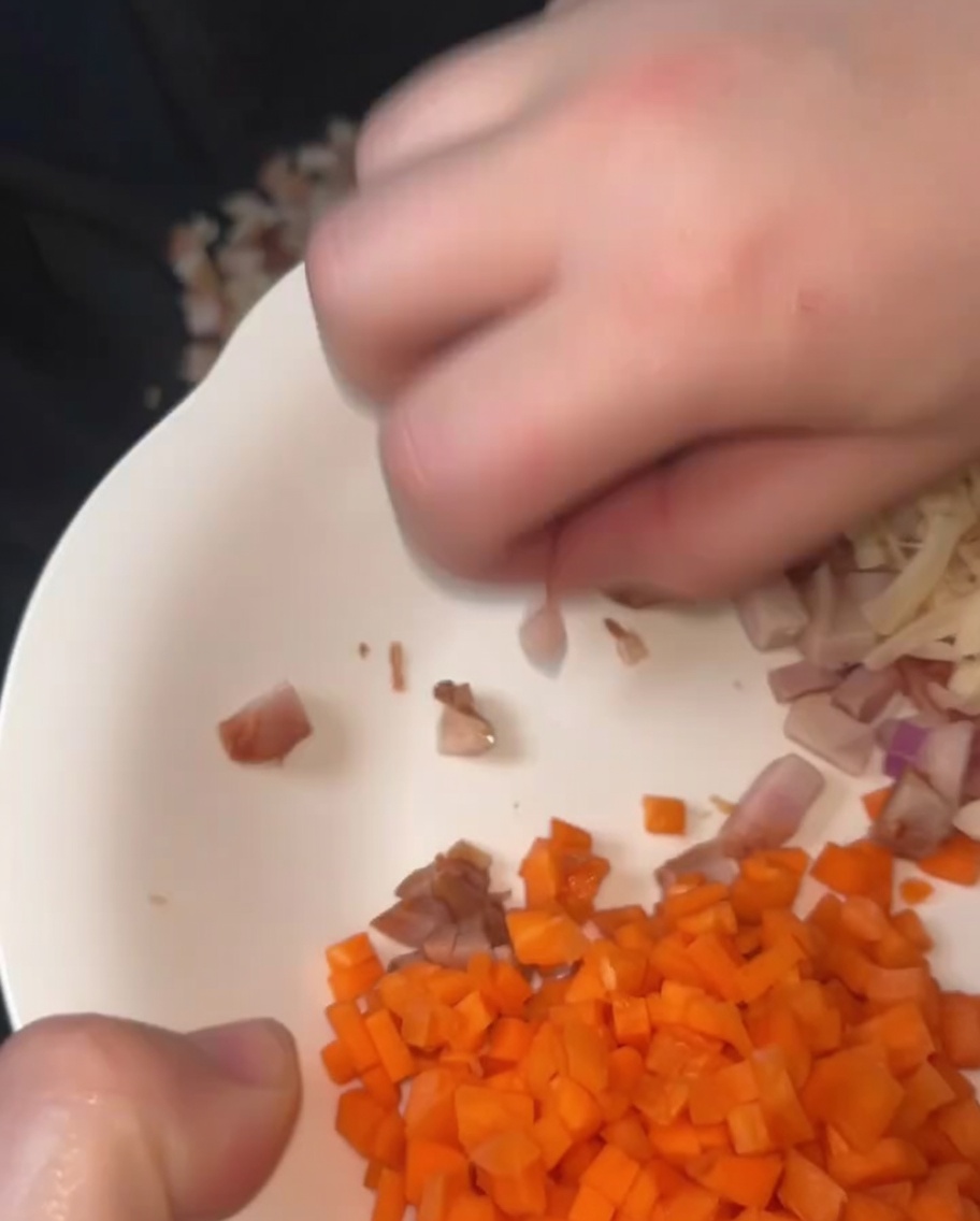Gewürfeltes Char Siu Schweinefleisch und getrocknete Jakobsmuscheln werden zusammen in einem eingebrannten Wok mit geschmolzenem Schmalz gebraten.