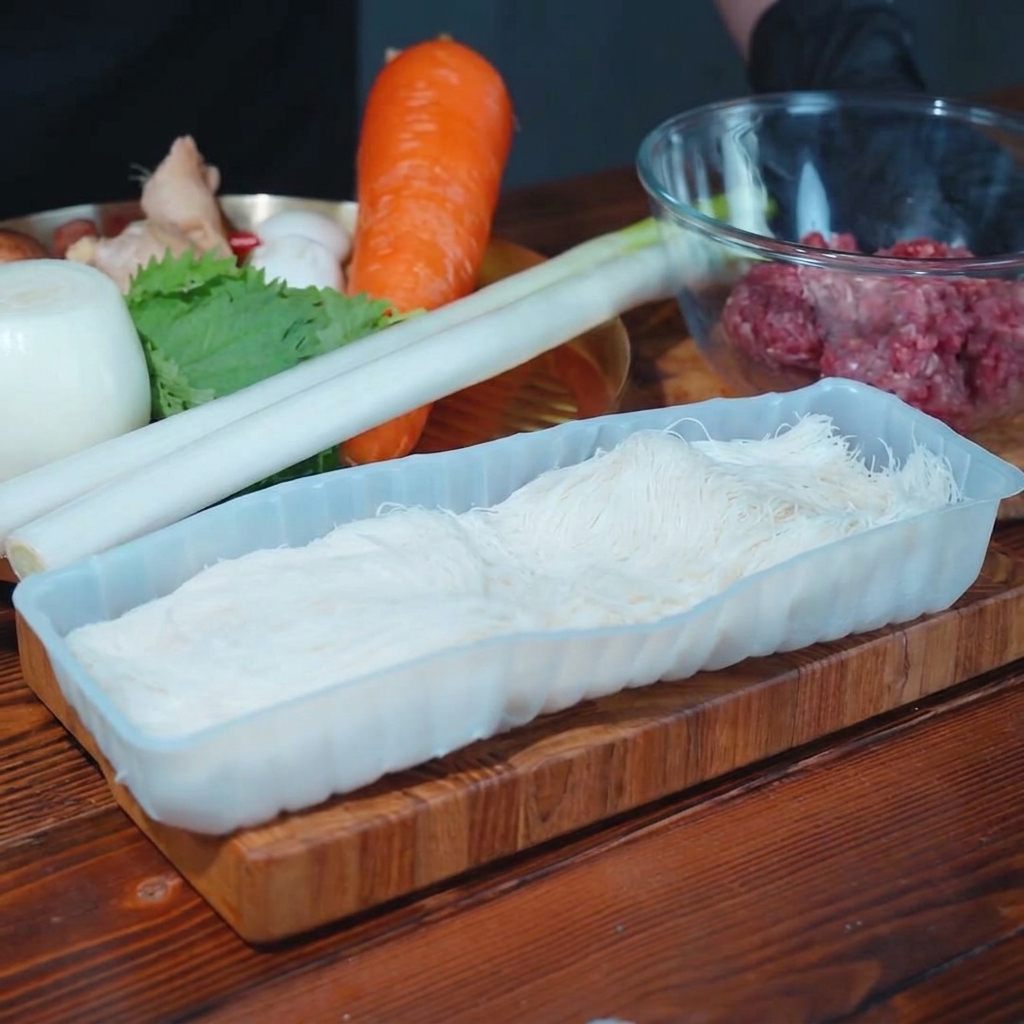 Frischer Lauch, Shiitake-Pilze und Zwiebelstücke auf einem Holzschneidebrett für die Füllung.