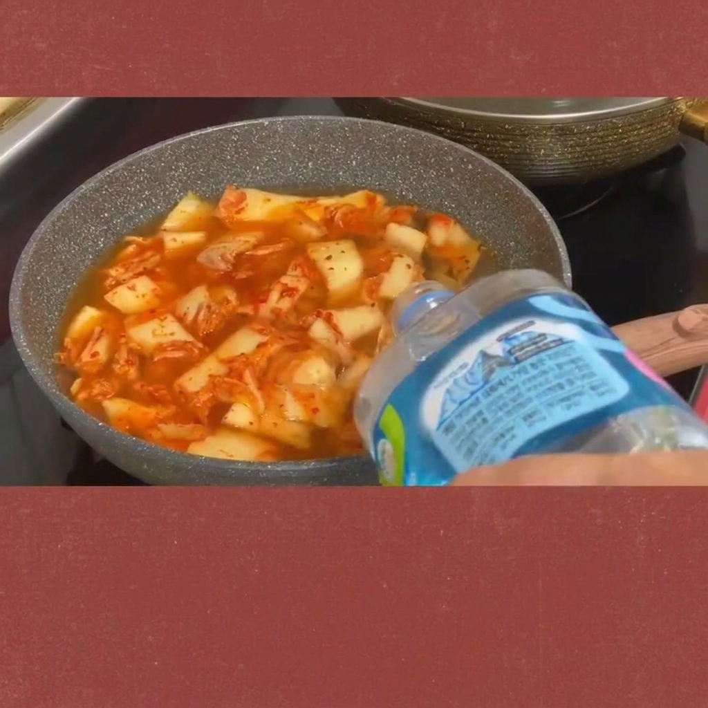 Scheiben von Spam werden in den kochenden Kimchi-Eintopf gegeben.