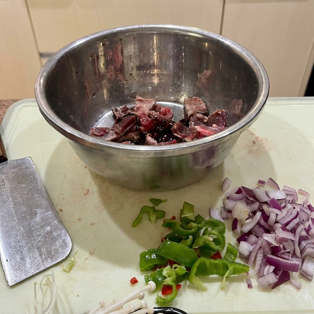Rindfleischstücke in einer Edelstahlschüssel mariniert mit Sojasauce, Austernsauce und Stärke.