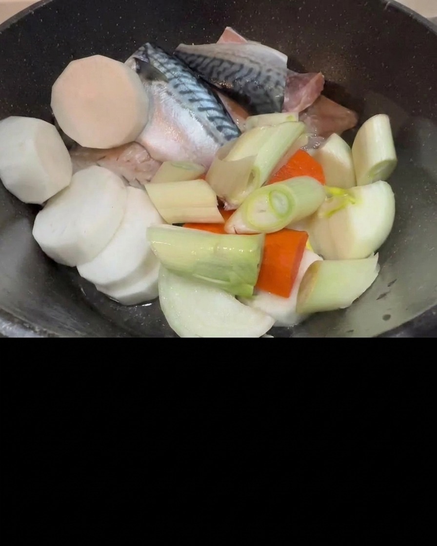Kimchi wird in den Topf mit roher Makrele, Rettich und Frühlingszwiebeln gegeben.