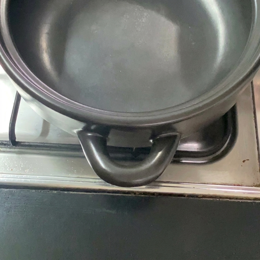 Nahaufnahme von geschnittenem, buntem Gemüse, das bereit zur Zubereitung im Tontopf ist.