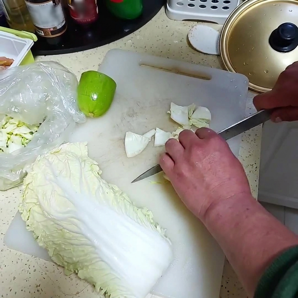 Frische Zwiebeln und eine kleine grüne Melone werden auf einem weißen Schneidebrett in Stücke geschnitten.