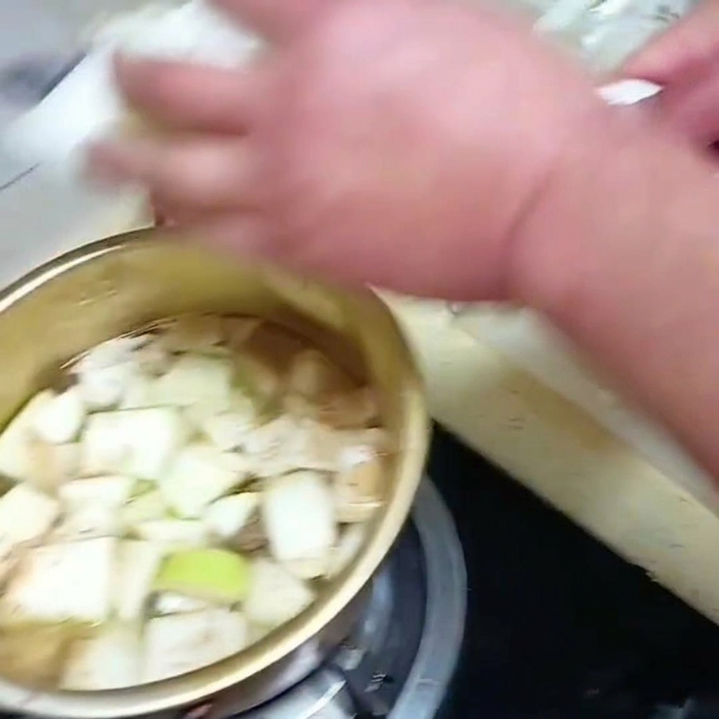 In Streifen geschnittener Chinakohl wird in den köchelnden Suppentopf zu dem anderen Gemüse gegeben.