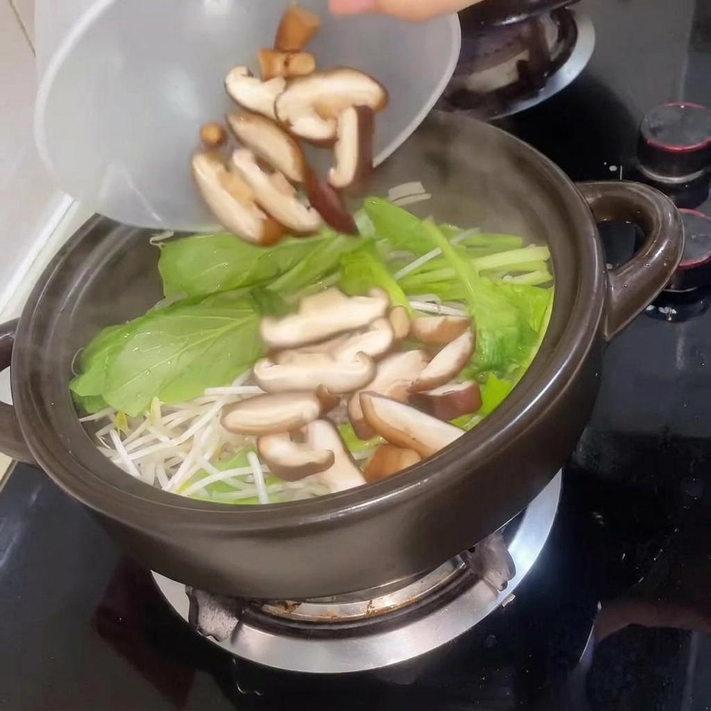 Geschnittene Shiitake-Pilze werden in den Topf gegeben, gefolgt von heißem Wasser.