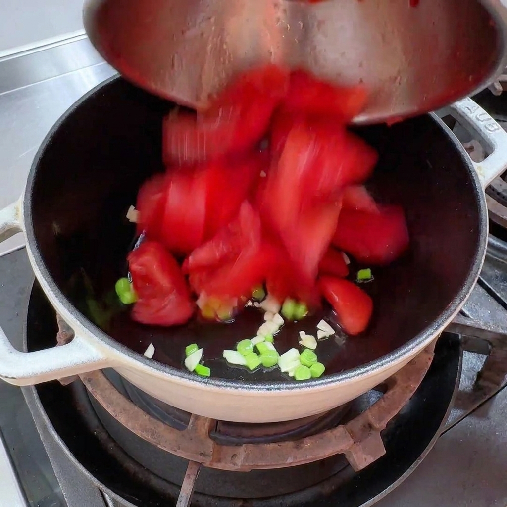 Frisch geschälte Tomatenstücke werden in einen Topf gegeben.