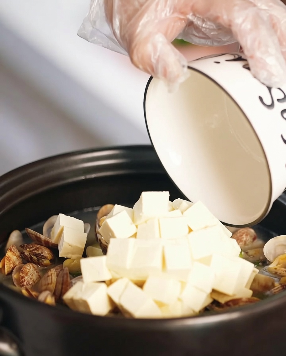 Tofu und gebratene Ei-Stücke werden in die Suppe gegeben.