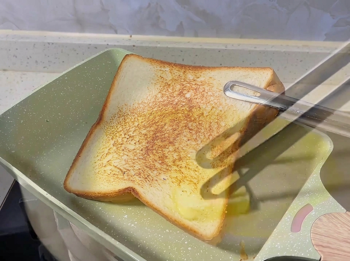 Gewürfelte rote Zwiebeln brutzeln in geschmolzener Butter in einer Pfanne.