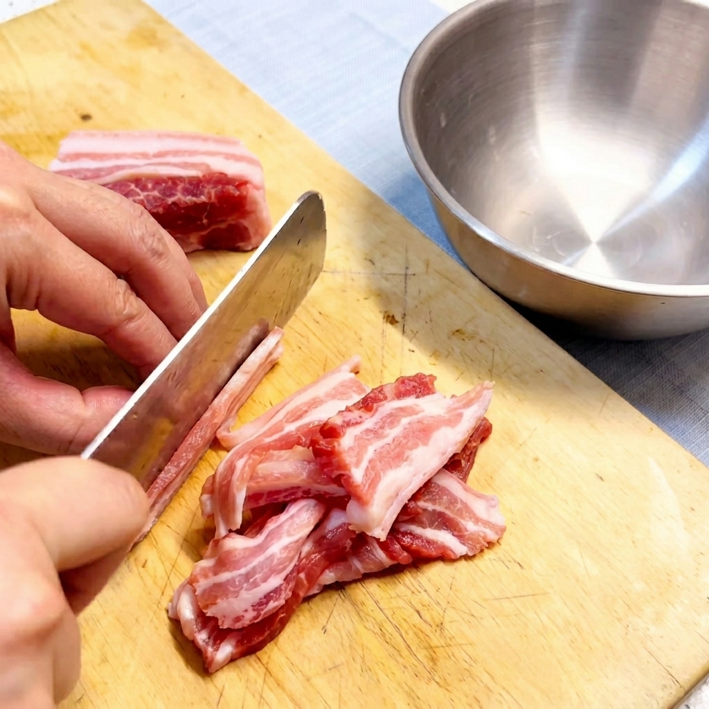 Rohe Schweinebauchscheiben liegen ordentlich auf einem Holzbrett bereit.
