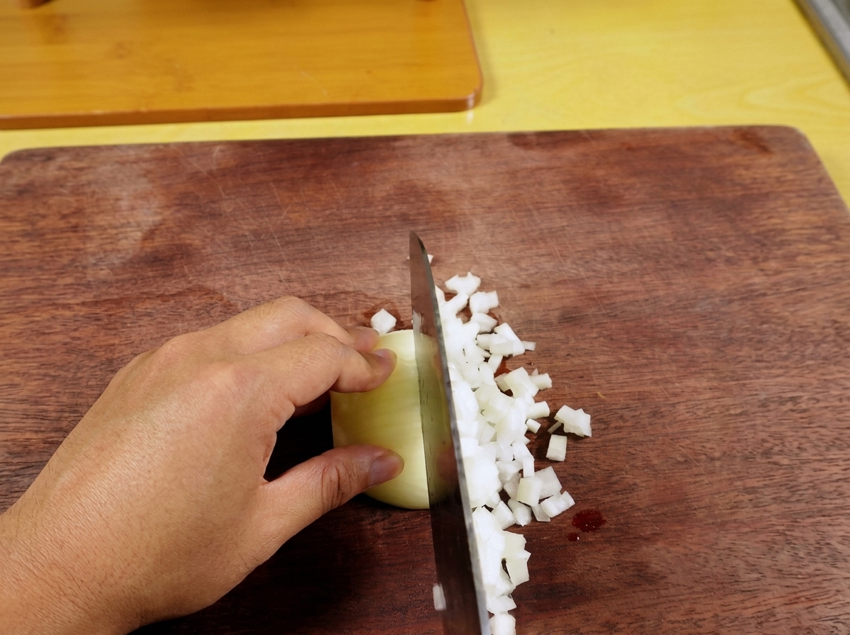 Frische grüne Chilischote wird auf einem Holzschneidebrett fein gehackt.