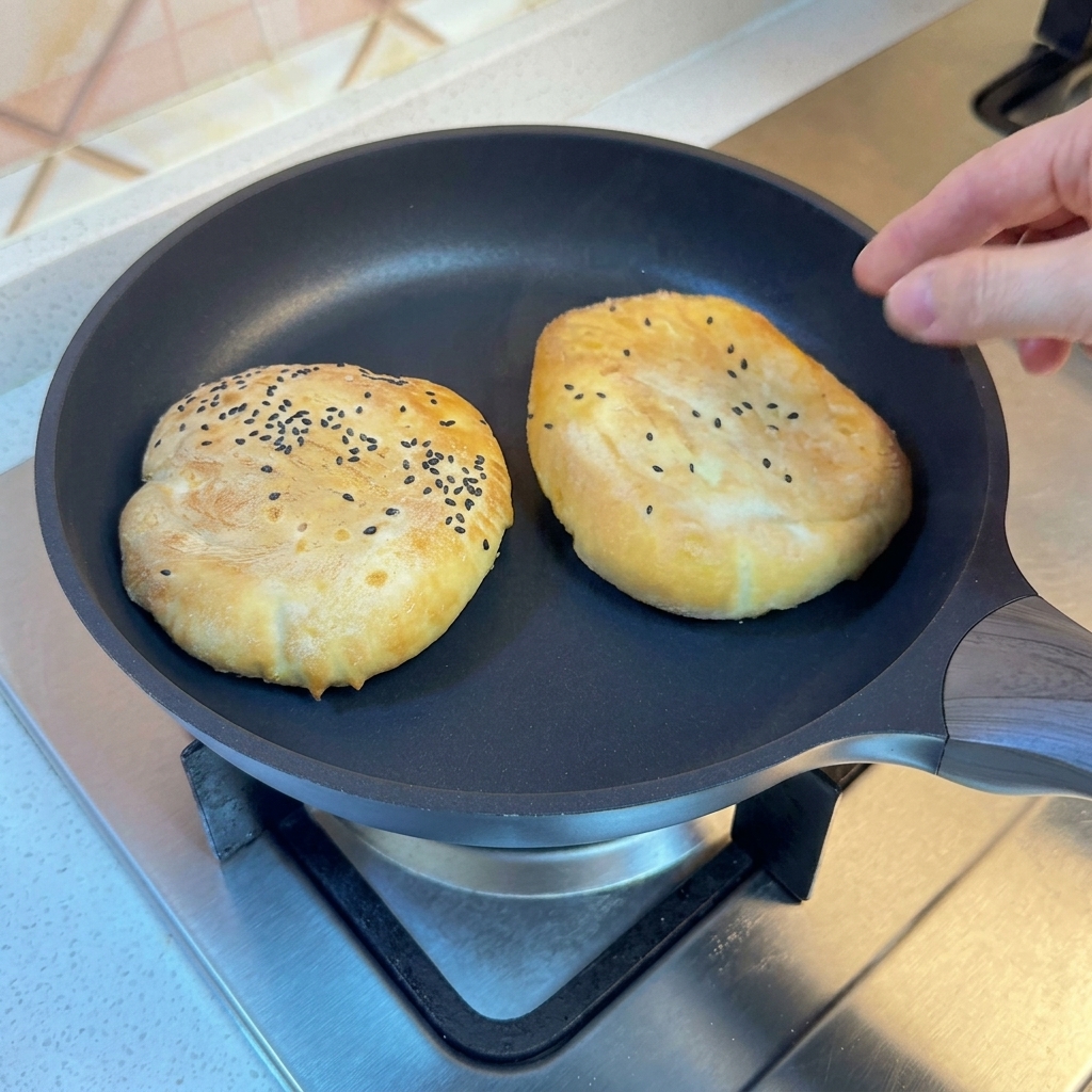 Brötchen in einer Pfanne, die mit einem Deckel abgedeckt ist.