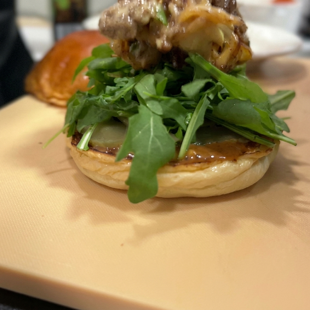 Die Fleisch-Käse-Mischung wird auf den Rucola gegeben.